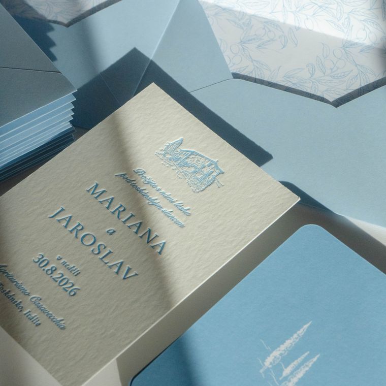 Krémové oznámení Mariana a Jaroslav s modrým letterpressem a obálky vyložené vzorem olivových větviček